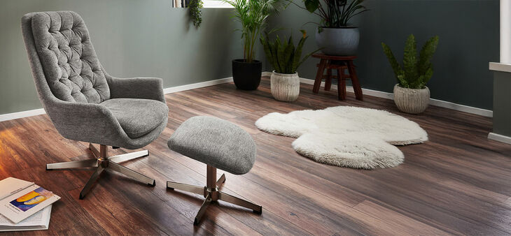 Gemütlicher grauer Sessel mit Fußablage