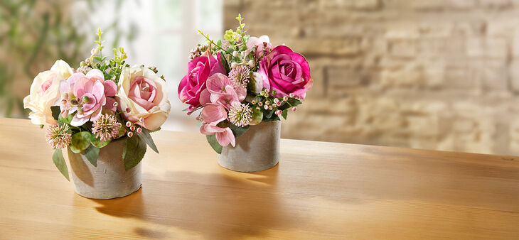 Zwei kleine Rosa-weiß und Pinke Rosengestecke in einem Topf.