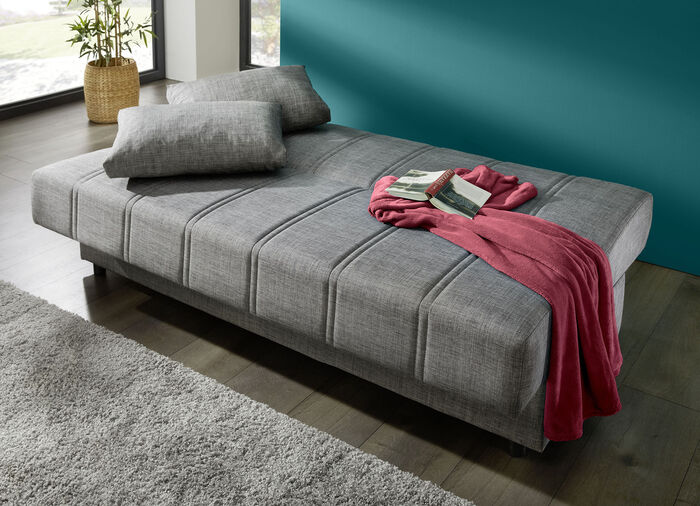 Frei im Raum aufstellbares Schlafsofa mit Dekokissen und Bettkasten GRAU